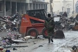 A soldier walks among rubble in Aleppo