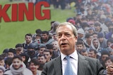 Nigel Farage stands in front of a large billboard with the words Breaking Point and an image of immigrants.