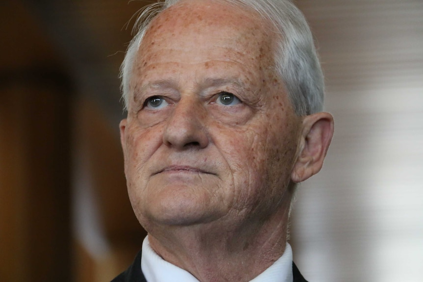 A close-up on the face of Philip Ruddock, who has a tight-lipped expression on his face.