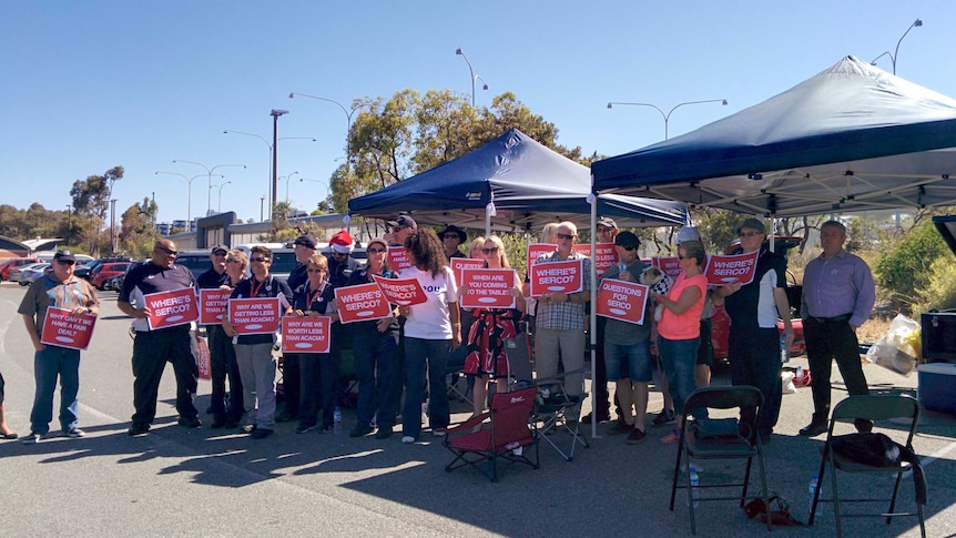 A group of staff outside Wandoo prison hold placards critical of Serco.