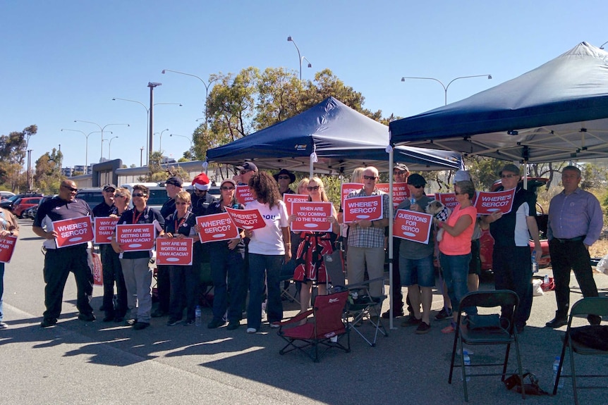 A group of staff outside Wandoo prison hold placards critical of Serco.