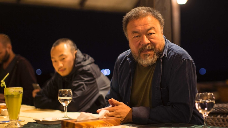 Chinese artist Ai Weiwei sits with members of his staff at the Al-Roots Hotel in Gaza City.