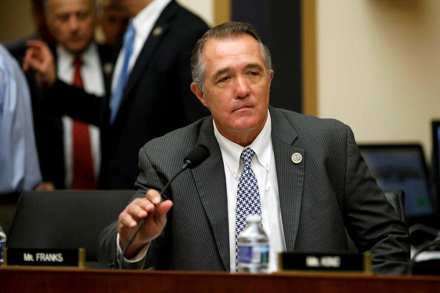 Trent Franks sits in front of a microphone.