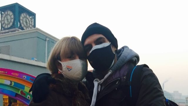 Two people wearing face masks to protect against smog.