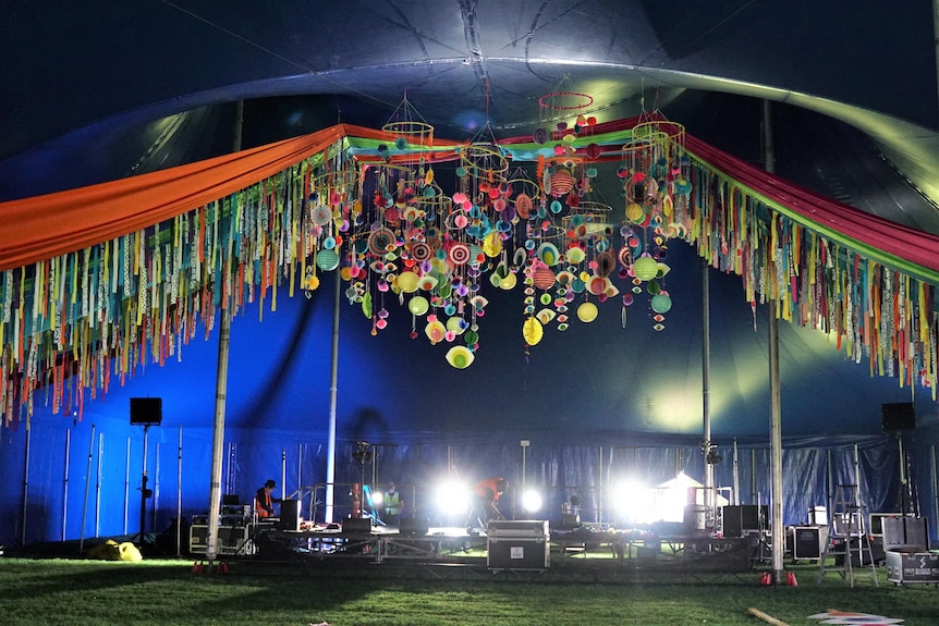 colourful piece of art with material hanging from festival tent roof 