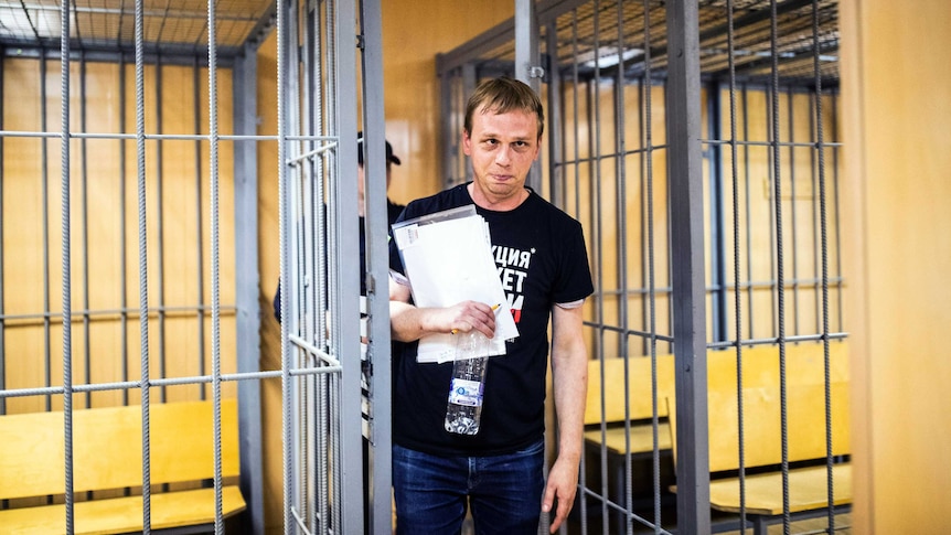 Prominent Russian investigative reporter Ivan Golunov leaves a courthouse cage.