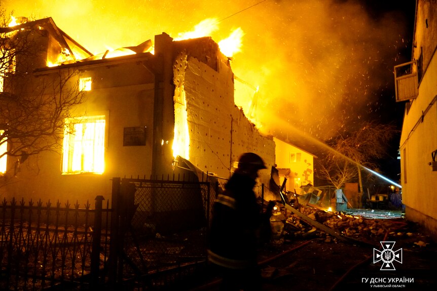 Petugas pemadam kebakaran bekerja di lokasi gedung yang terbakar 