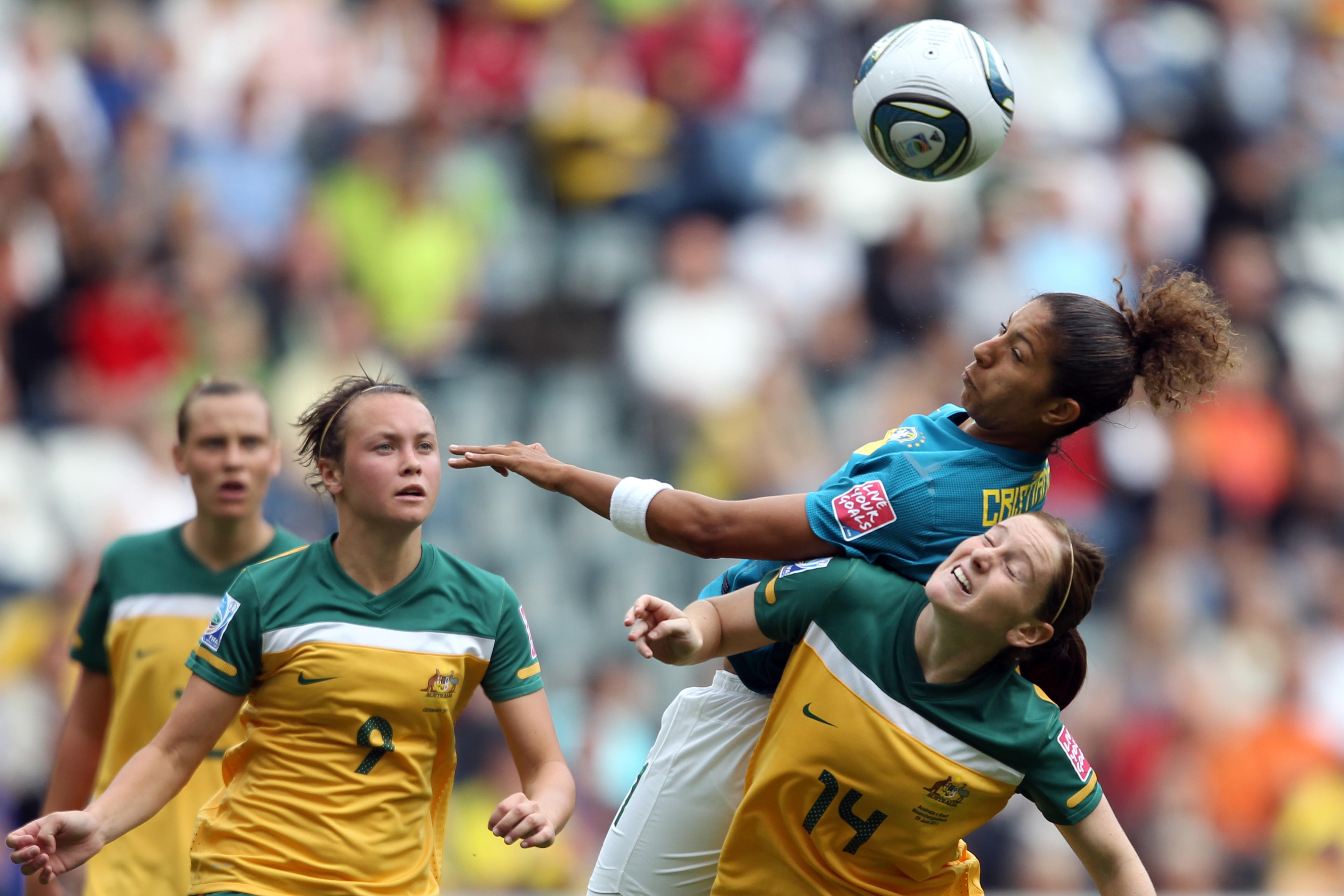 Emily van Egmond and Caitlin Foord watch Matildas teammate Collette McCallum compete for the ball with Brazil's Cristiane.