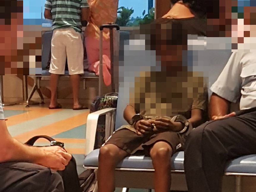 A photo of a juvenile offender in handcuffs at Broome airport.