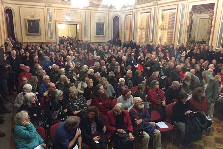 People are packed into the Hobart Town Hall.