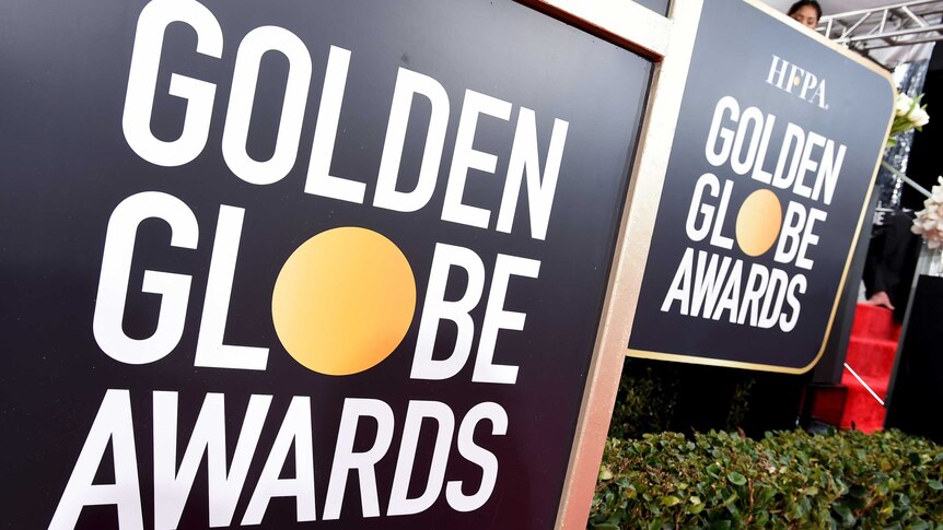 Two signs that say "Golden Globe Awards" are pictured next to a hedge.