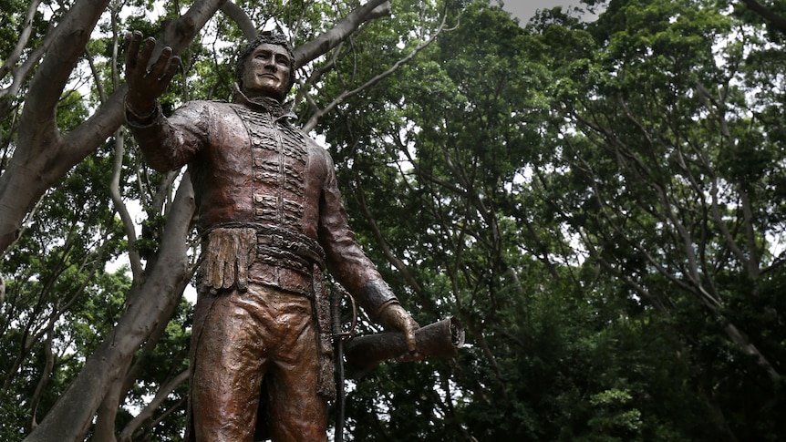 Bronze statue in a park in front of trees