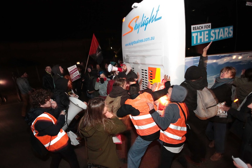 Protesters obstruct a bus outside Lauren Southern event