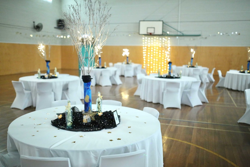 Several tables in a large room, pictured before guests arrive.