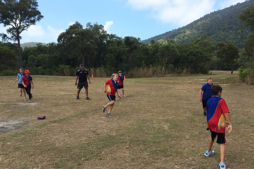 Matt Bowen playing football with kids at Cooktown State School
