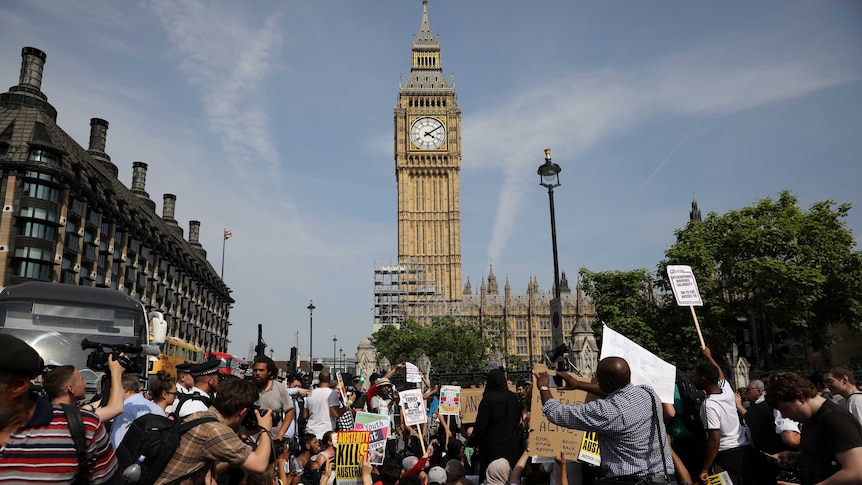 Demonstrators sit in the road in Parliament Square.