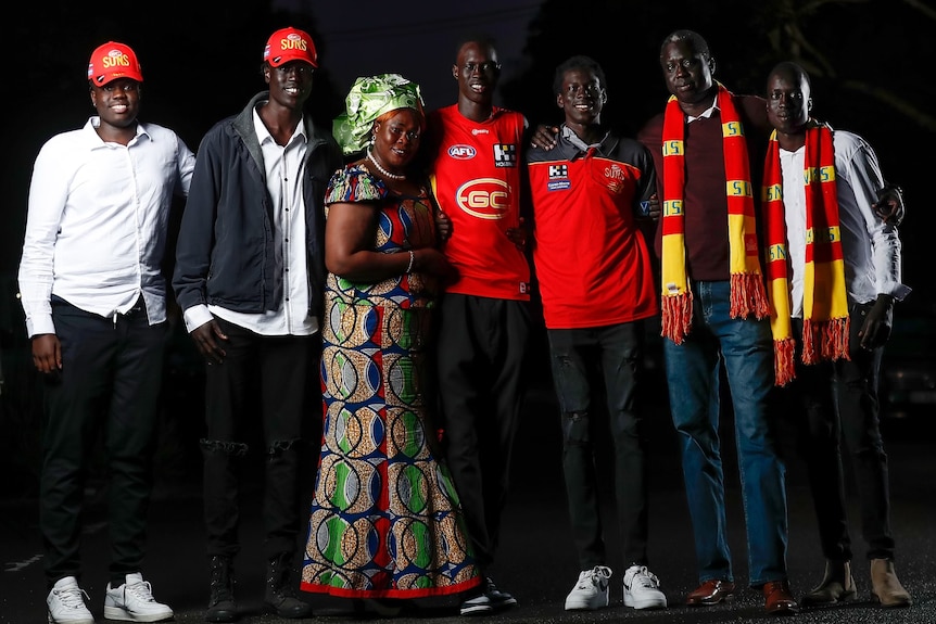 Mac Andrew surround by his family wearing Gold Coast Suns colours.