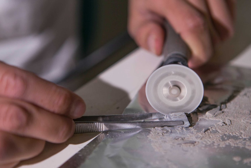 Close up of drill removing material from fossil