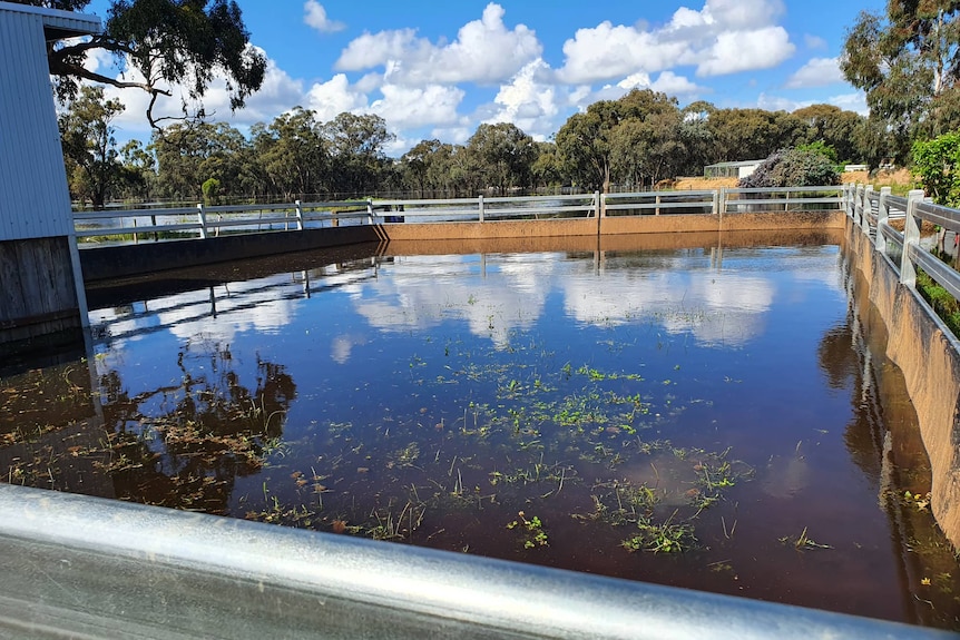 A flooded stable with a tall fence around it.