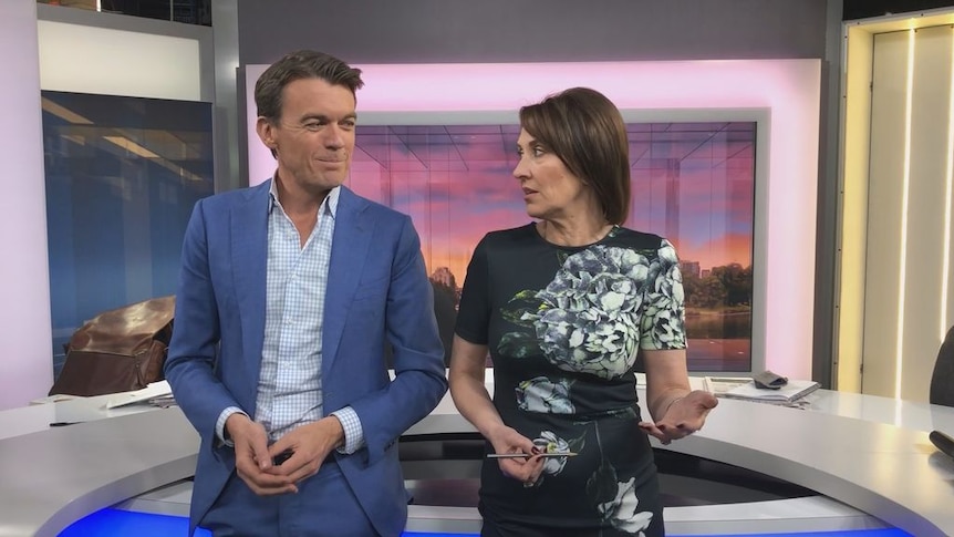 Michael Rowland and Virginia Trioli stand at the news desk.