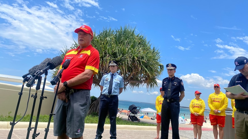A lifesaver holds a press conference on the beach.