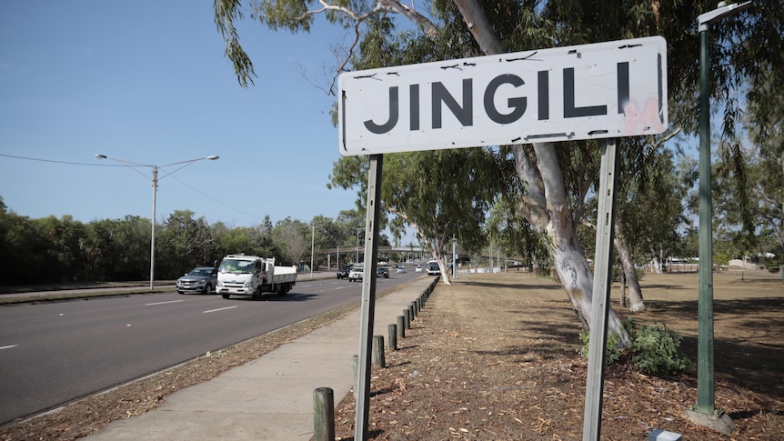 The suburb sign of Jingili located next to a busy arterial road.