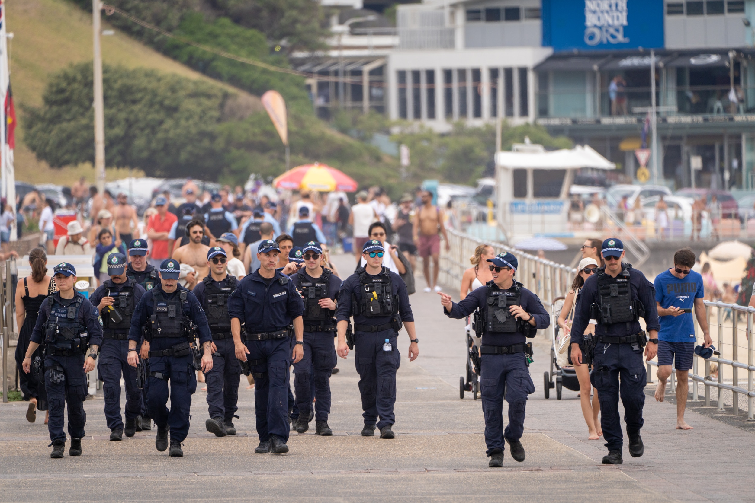 Uma fila de policiais caminhando pelo Pavilhão Bondi.