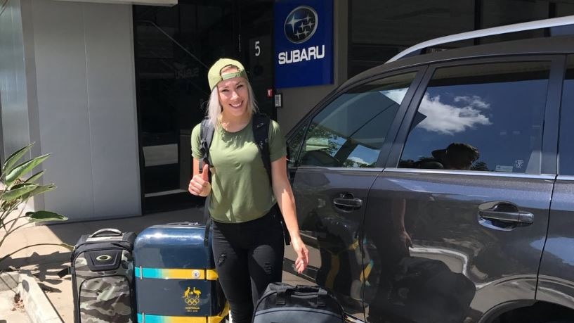 Caroline Buchanan standing in front of a black Subaru.