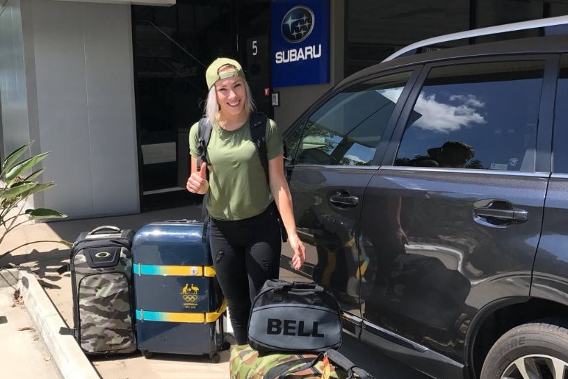 Caroline Buchanan standing in front of a black Subaru.