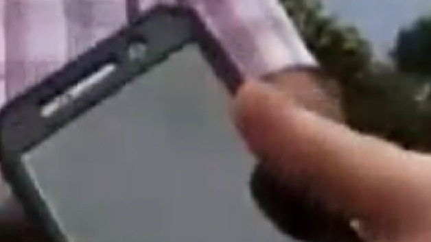 A mobile phone with someone's hand holding it.