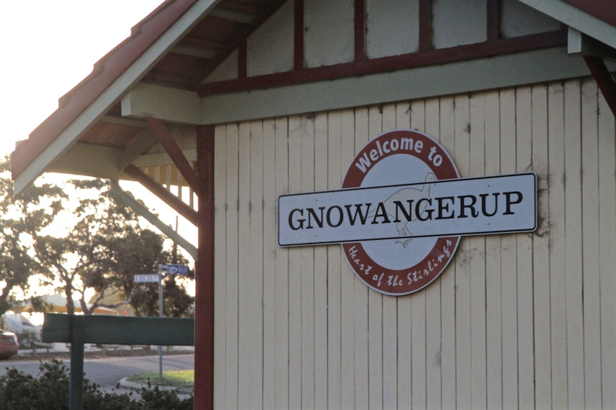 A sign saying welcome to Gnowangerup on the side of a small wood building