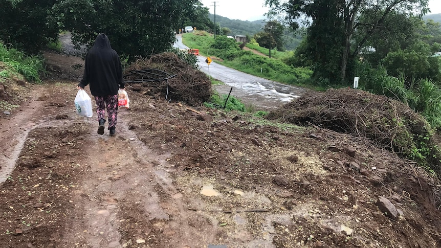 a person carrying groceries alongside the landslide