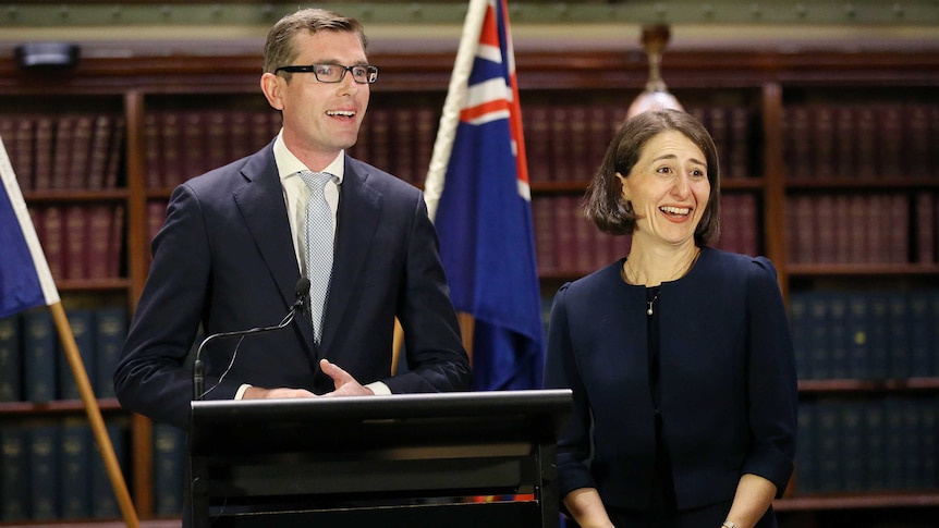 The treasurer and premier standing side by side smiling