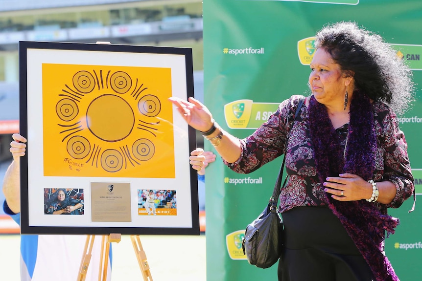 Fiona Clarke shows her Indigenous painting at the MCG
