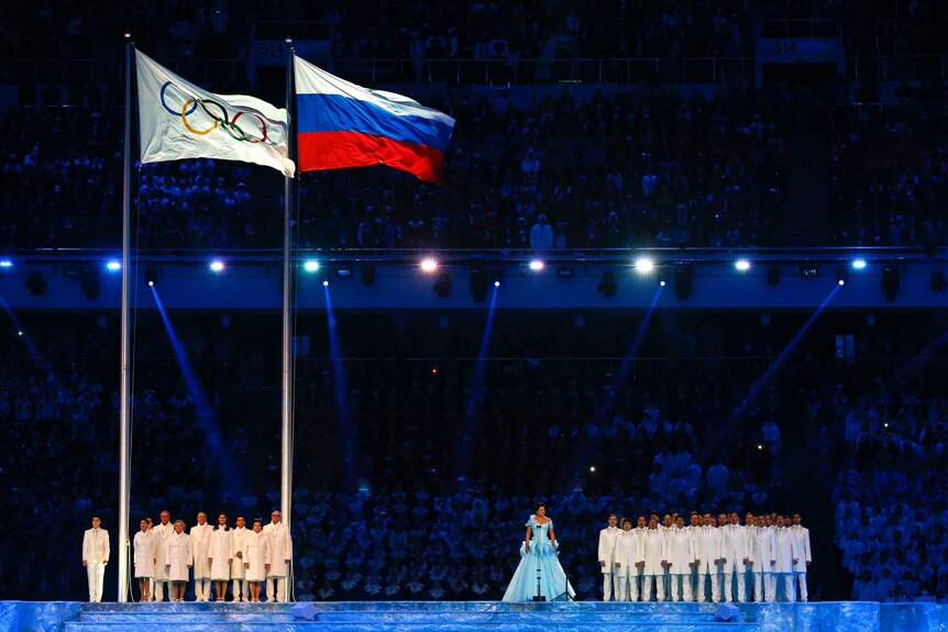 The Olympic flag is raised next to the Russian flag at opening ceremony of Sochi Winter Olympics.