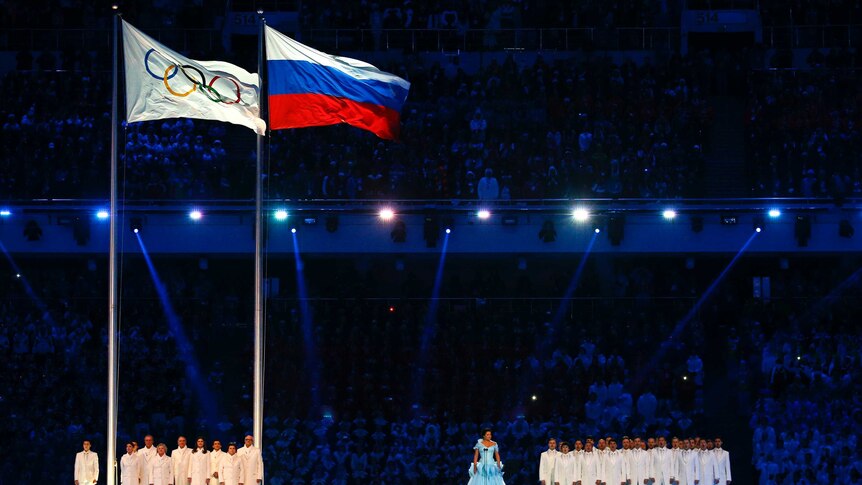 The Olympic flag is raised next to the Russian flag at opening ceremony of Sochi Winter Olympics.