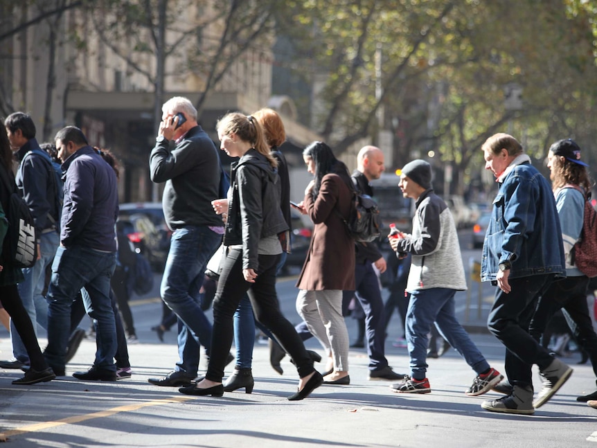 Pedestrians cross the street in  Melbourne's CBD June 2017