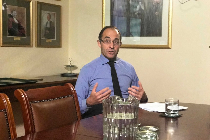 Chief Justice Chris Kourakis sits at a table