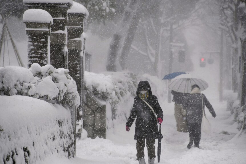 People make their way in the heavy snow in Kanazawa, Ishikawa Prefecture, central Japan.