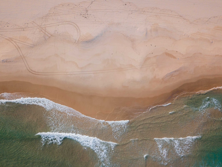 Turquoise water, waves and sand taken from a drone above Bondi Beach