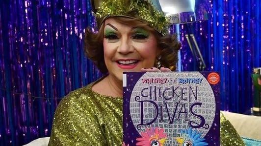 A picture of a drag queen holding a children's book