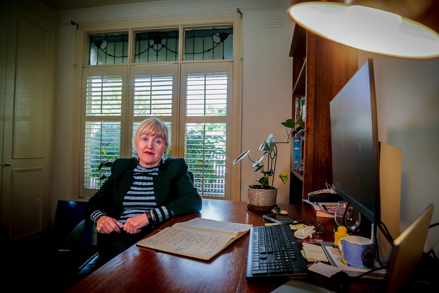 A woman sitting at a desk in a home office 