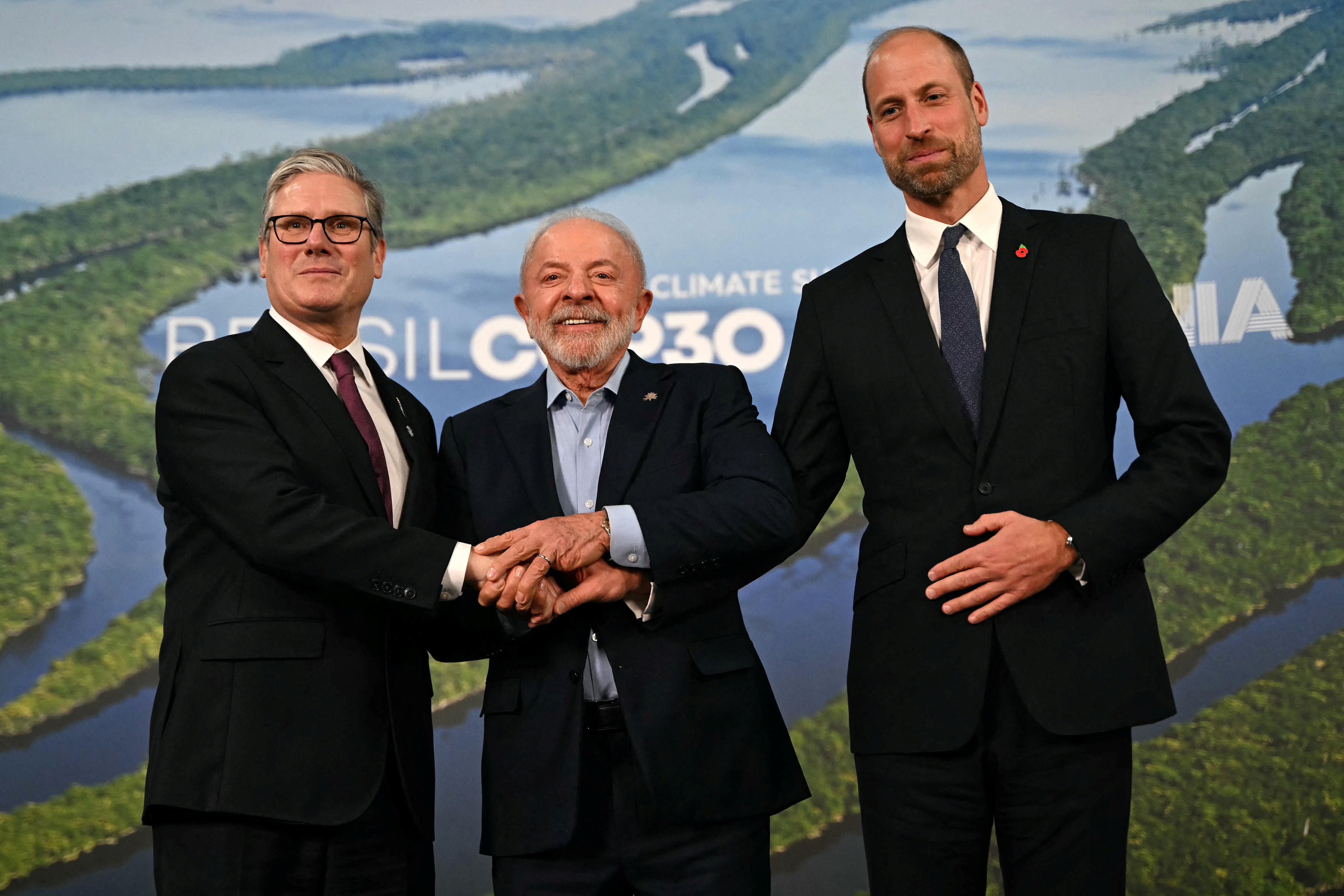 Three men standing in front of a screen with the Amazon River on it.