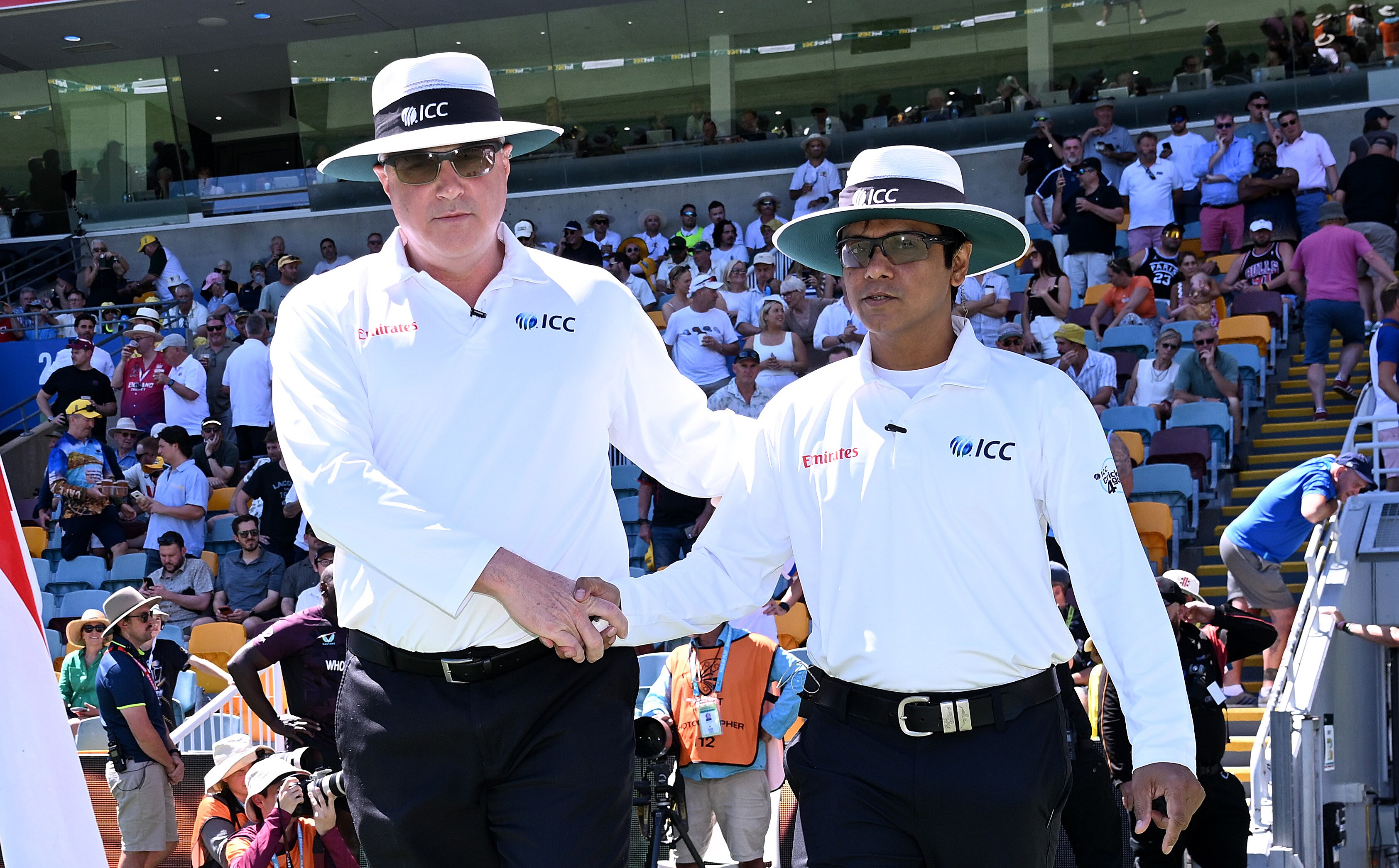 Los árbitros Adrian Holdstock y Sharfuddoula Saikat se dan la mano antes de entrar al campo para la prueba Gabba Ashes.