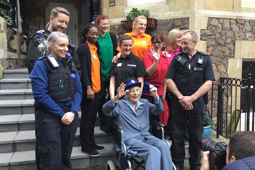 Anne Brokenbrow poses for a photo with the police officers who mock arrested her.