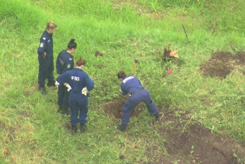 police officers digging in a field
