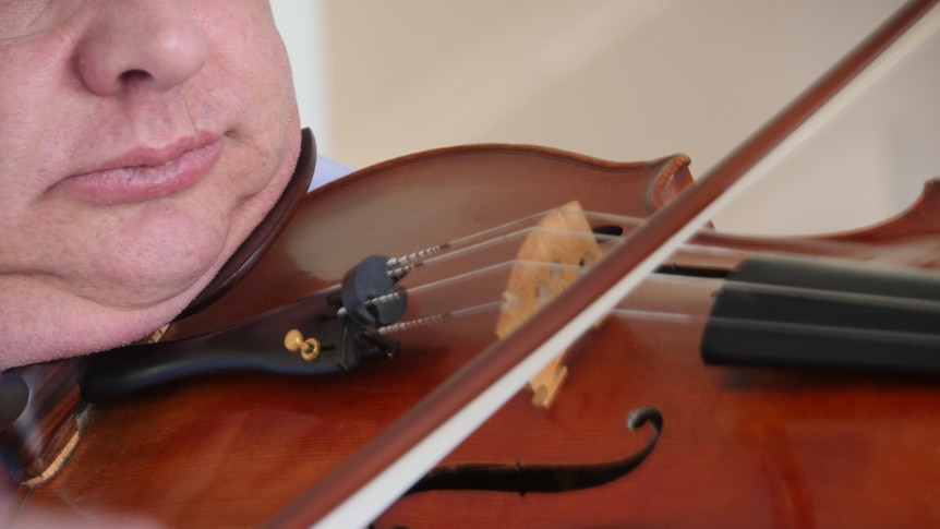 A man holding a viola to his chin.