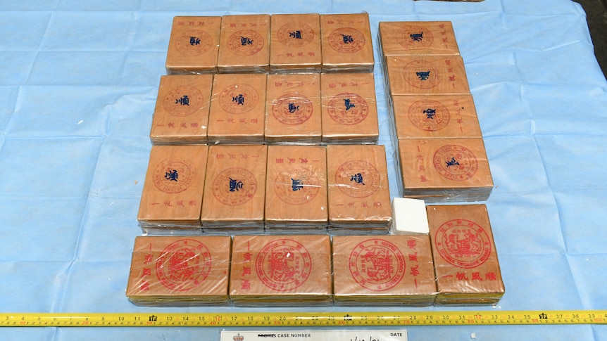 Boxes containing the drug heroin laid out on a blue sheet.