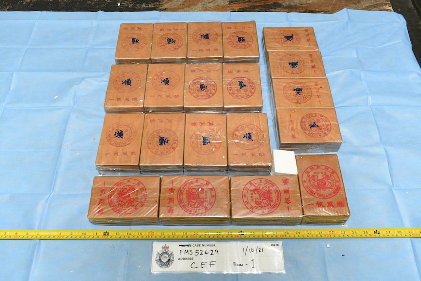 Boxes containing the drug heroin laid out on a blue sheet.