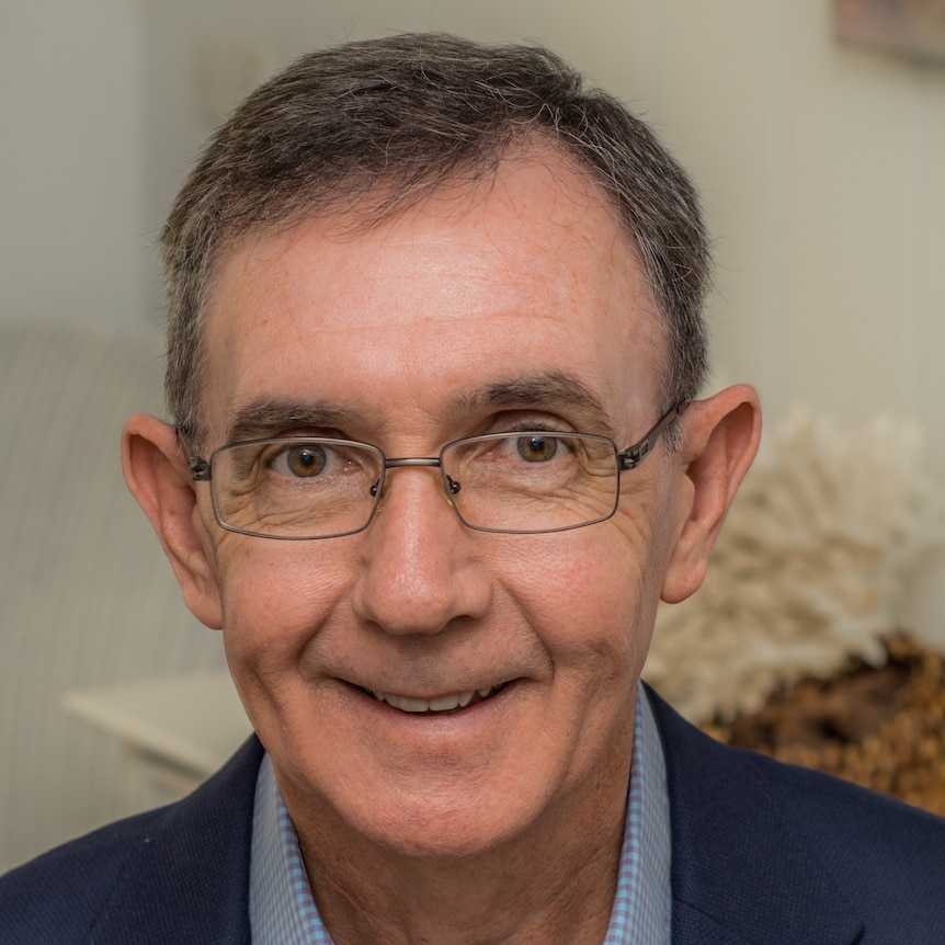 Man wearing glasses smiles at camera